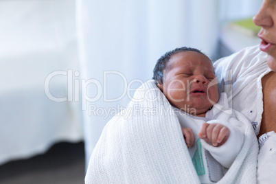 Mother consoling newborn baby in hospital