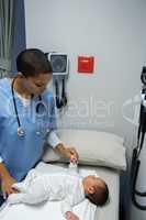 Doctor examining baby in medical examination room