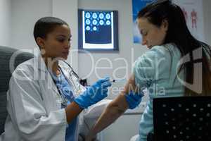 Female doctor giving injection to female patients in the hospital