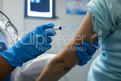 Female doctor giving injection to female patients in the hospital