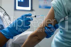 Female doctor giving injection to female patients in the hospital