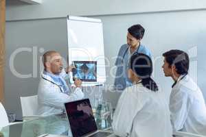 Medical team discussing over x-ray report at the table