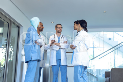 Medical team of doctors talking with each other in lobby at hospital