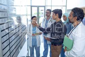 Medical team of doctors discussing their shifts on chart at hospital