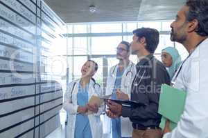Medical team of doctors checking their shifts on chart at hospital