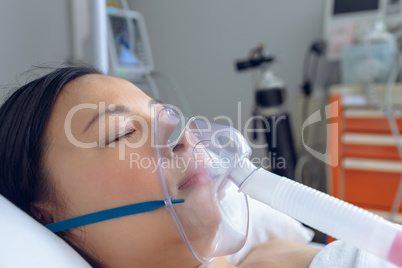 Female patient resting in bed in ward at hospital