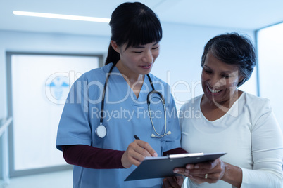 Female doctor interacting with female patient in the corridor
