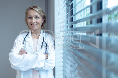 Female doctor standing with arms crossed in the hospital