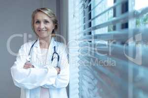 Female doctor standing with arms crossed in the hospital