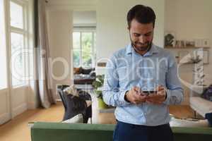 Man using mobile phone in a comfortable home