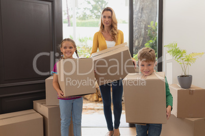Mother and children holding cardboard boxes in a comfortable home