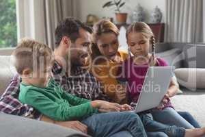 Caucasian family using laptop on the sofa in a comfortable home