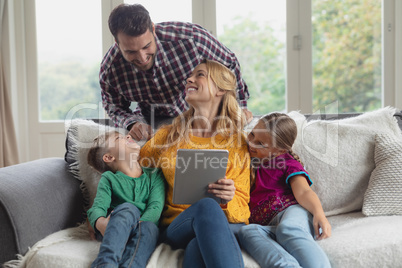 Family using digital tablet on the sofa in a comfortable home