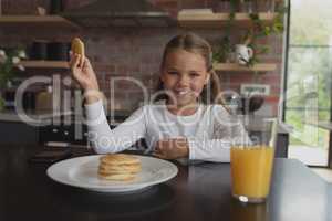 Girl having food at dining table at home