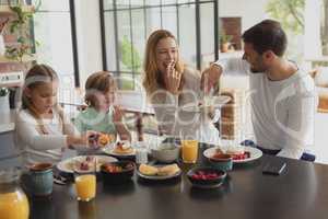 Caucasian family having food at dining table