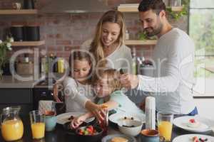 Caucasian family having food at dining table
