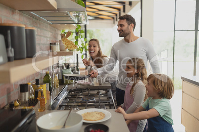 Family preparing food in kitchen at home