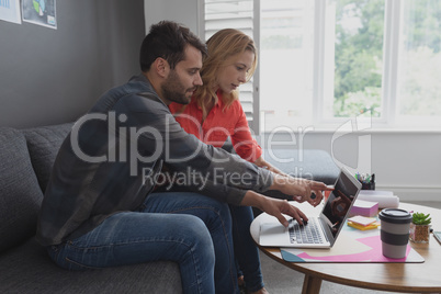 Business executives discussing over laptop