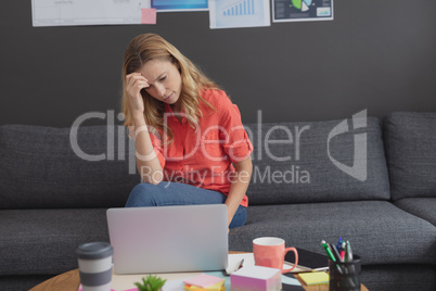 Tensed female executive working on laptop