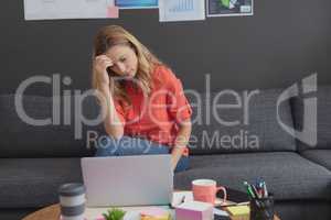 Tensed female executive working on laptop