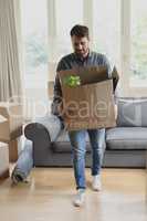 Man holding cardboard box in new home