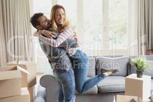 Romantic man holding woman in arms at home