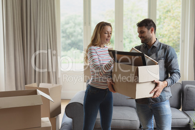 Couple holding cardboard box in new home