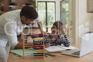 Father helping his son with homework in a comfortable home
