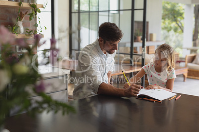 Father helping his daughter with homework in a comfortable home