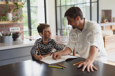 Father helping his son with homework in a comfortable home