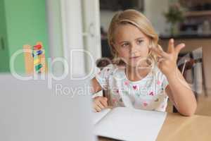 Girl doing homework at table in a comfortable home