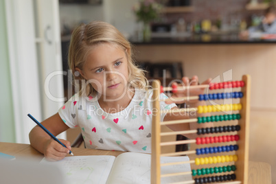 Girl doing homework at table in a comfortable home