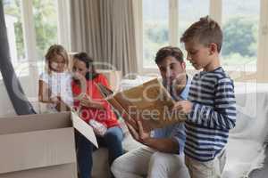 Family looking at photo album in living room