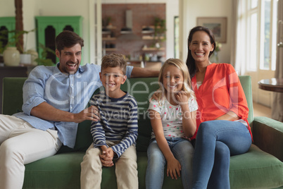 Family sitting together on sofa in living room art home