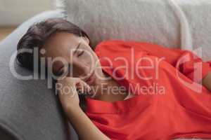 Woman sleeping on a sofa in living room at home