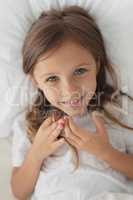 Girl relaxing in bed in bedroom at home