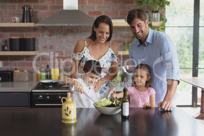 Family preparing vegetable salad in kitchen at home Family preparing vegetable salad in kitchen at home