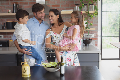Family preparing vegetable salad in kitchen at home