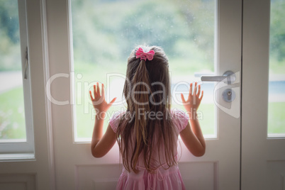Girl looking through door at home