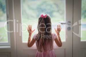 Girl looking through door at home