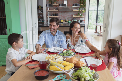 Family interacting with each other at dining table in comfortable home