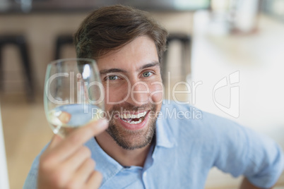 Happy man holding glass of champagne at home Happy man holding glass of champagne at home