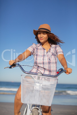 Beautiful woman sitting on bicycle at beach in the sunshine