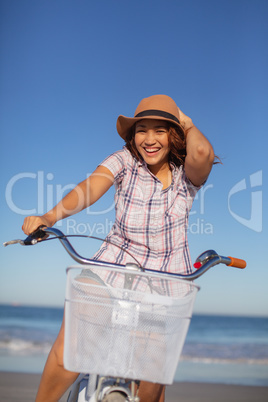 Beautiful woman sitting on bicycle at beach in the sunshine
