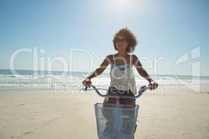 Woman riding a bicycle at beach on a sunny day