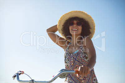 Woman with bicycle at beach on a sunny day