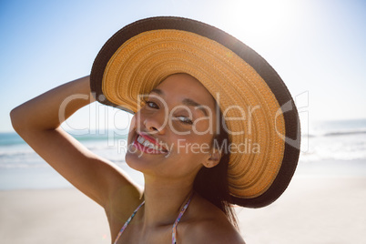 Beautiful woman in hat standing on the beach