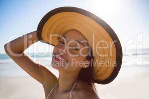 Beautiful woman in hat standing on the beach