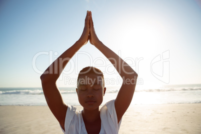 Woman performing yoga on the beach