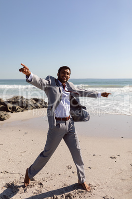 Happy young Businessman dancing on the beach